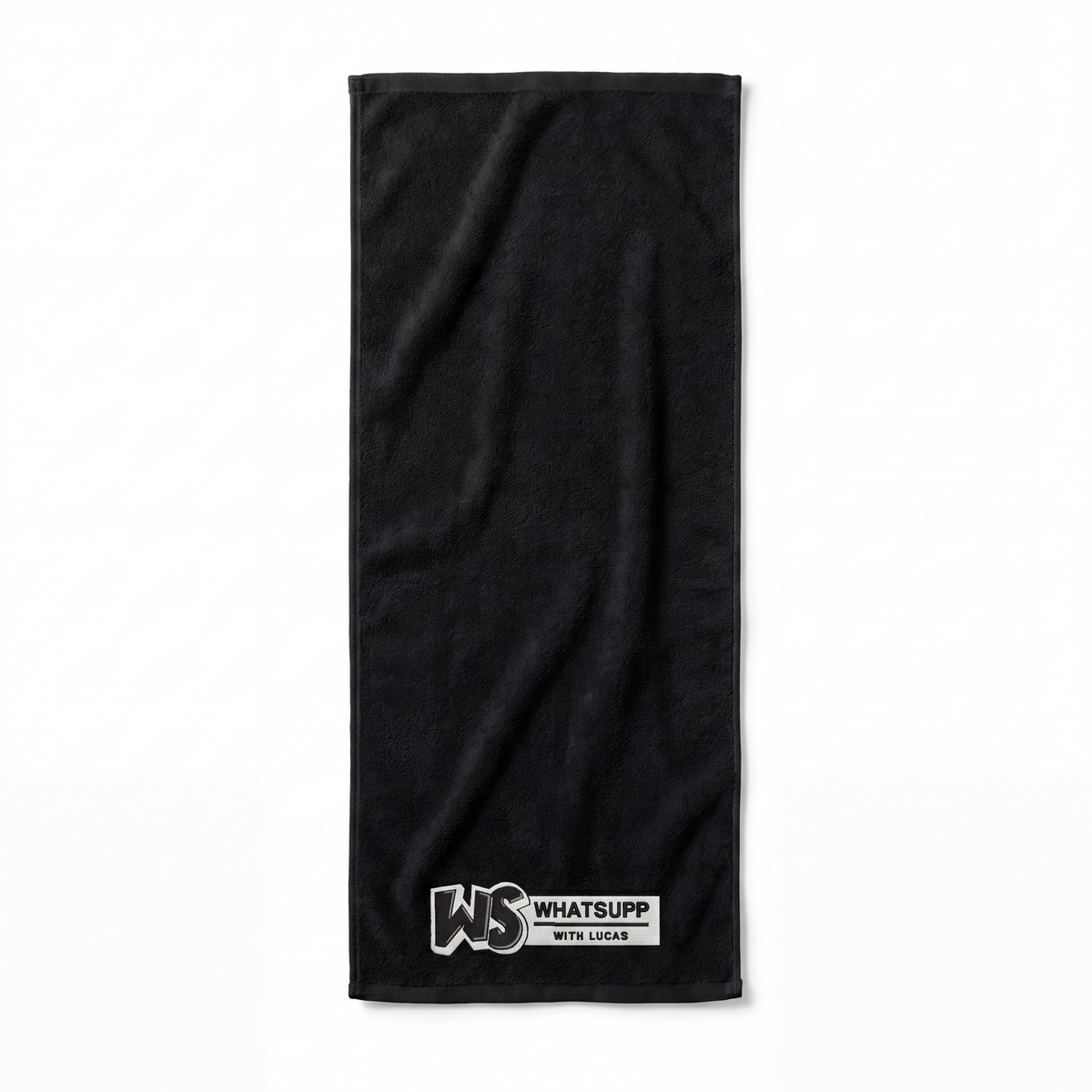Black Whatsuppwithlucas gym towel fully unfolded and laid flat, showing its full length